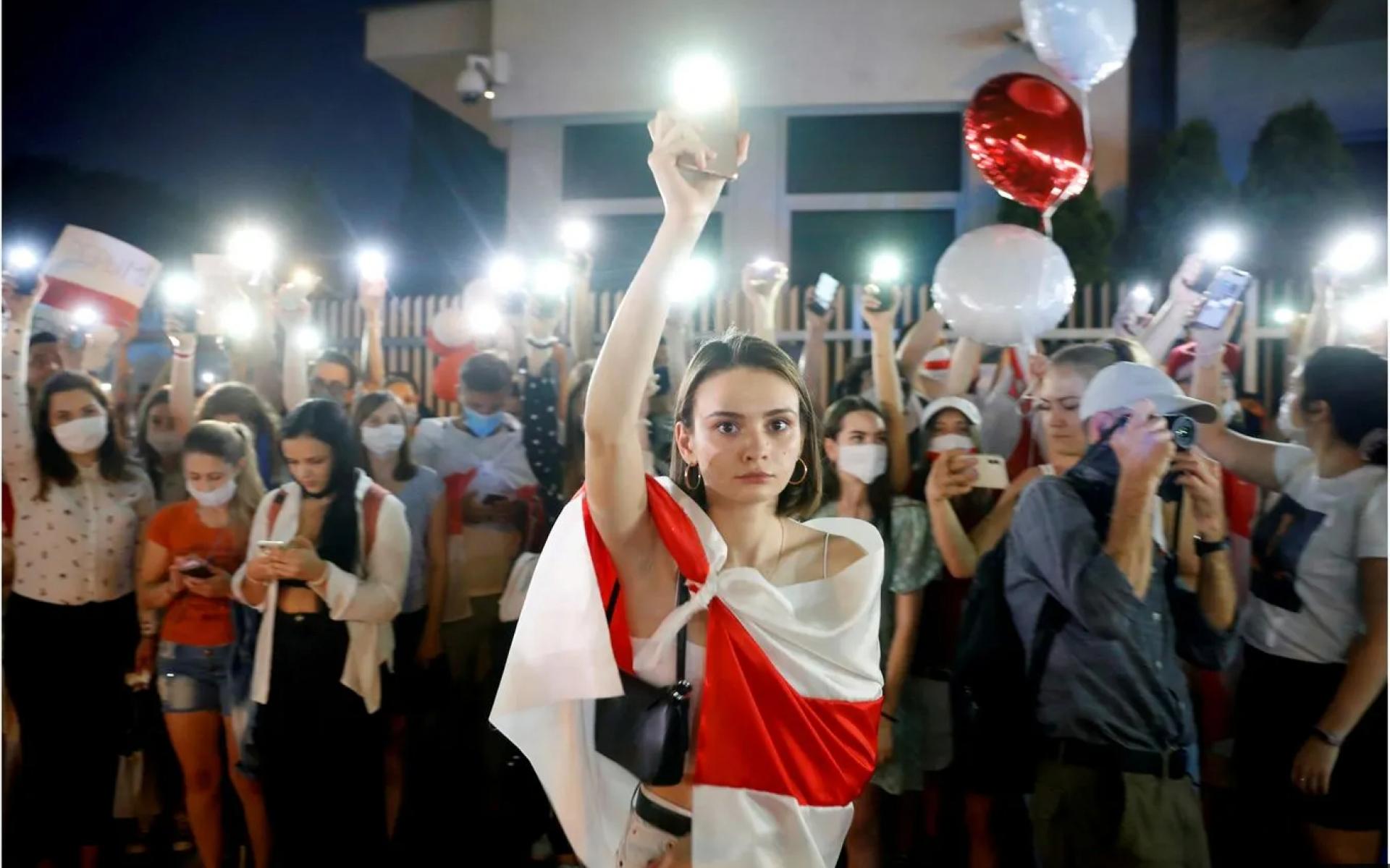 متظاهرة تمسك هاتفها خلال مسيرة بعد الانتخابات الرئاسية المتنازع عليها في بيلاروسيا ، أغسطس 2020